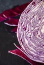 Close-up detail of half cut red cabbage, with pieces, on wet black slate Royalty Free Stock Photo
