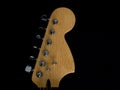 Close-up of the detail of the headstock of an electric guitar on a black background