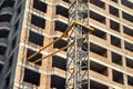 Close-up detail of highrise tower crane attached to building brick wall at hightower industrial construction site Royalty Free Stock Photo