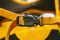 Close-up detail of locked black convenient plastic clasp of backpack yellow