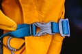 Close-up detail of locked blue convenient plastic clasp of backpack yellow