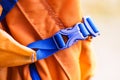 Close-up detail of locked blue convenient plastic clasp of backpack yellow