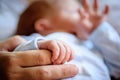 Close-up detail macro view of baby holding on to mom`s finger with his little hand Royalty Free Stock Photo