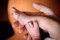 Close-up detail of mother holding cute and soft baby small leg in her hands Royalty Free Stock Photo