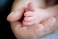 Close-up detail of mother holding cute and soft baby small leg in her hands Royalty Free Stock Photo