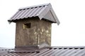 Close-up detail of new plastered chimney on house top with metal tile roof under construction. Royalty Free Stock Photo