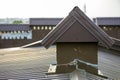 Close-up detail of new built brick plastered chimneys on house top with metal tile roof. Roofing, repair and renovation work Royalty Free Stock Photo