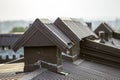 Close-up detail of new built brick plastered chimneys on house top with metal tile roof. Roofing, repair and renovation work Royalty Free Stock Photo