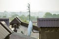 Close-up detail of new built brick plastered chimneys on house top with metal tile roof. Roofing, repair and renovation work Royalty Free Stock Photo