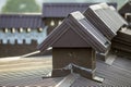 Close-up detail of new built brick plastered chimneys on house top with metal tile roof. Roofing, repair and renovation work Royalty Free Stock Photo