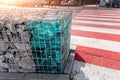 Close-up detail of new modern beautiful gabion fence with metal cage filled by crushed stone and shattered artificial