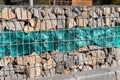 Close-up detail of new modern beautiful gabion fence with metal cage filled by crushed stone and shattered artificial Royalty Free Stock Photo