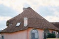 Close-up detail of new modern ecological cottage house top with shingled brown roof on blue sky background Royalty Free Stock Photo