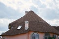 Close-up detail of new modern ecological cottage house top with shingled brown roof on blue sky background. Royalty Free Stock Photo