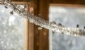 Close-up detail new year Christmas decoration, silver stars and rain on window light blurred bokeh background. Sparkling DIY Royalty Free Stock Photo