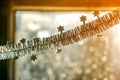 Close-up detail new year Christmas decoration, silver stars and rain on window light blurred bokeh background. Sparkling DIY Royalty Free Stock Photo