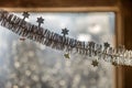 Close-up detail new year Christmas decoration, silver stars and rain on window light blurred bokeh background. Sparkling DIY Royalty Free Stock Photo