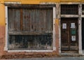 Old worn down building entrance with big boarded window Royalty Free Stock Photo