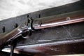 Close up detail of old flintlock rifle or musket, hanging on an old oak beam