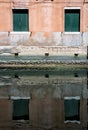 Close up detail with old medieval architecture venetian window. Reflection in the water of a worn out brick wall building with Royalty Free Stock Photo