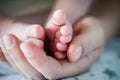 Close-up detail of parent holding cute and soft baby small leg in his hands Royalty Free Stock Photo