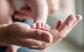 Close-up detail of parent holding cute and soft baby small leg in his hands Royalty Free Stock Photo