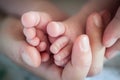 Close-up detail of parent holding cute and soft baby small leg in his hands Royalty Free Stock Photo