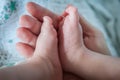 Close-up detail of parent holding cute and soft baby small leg in his hands Royalty Free Stock Photo