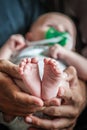 Close-up detail of parent holding cute and soft baby small leg in his hands Royalty Free Stock Photo