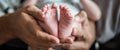 Close-up detail of parent holding cute and soft baby small leg in his hands Royalty Free Stock Photo