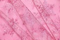 Abstract textured background of pink net ribbon with glitter snowflakes Royalty Free Stock Photo