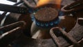 Close up detail shot of old rusty kitchen stove ring switched on fire with lighter flame burning in dangerous gas energy and