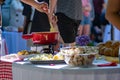 Close up detail shot of person's arm stirring a traditional tasty delicious pot of hot melted liquid swiss cheese fondue