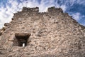 Close up detail of stone medieval castle wall with window in blue sky with clouds, crni kal, slovenia