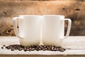 Two Mugs in Sunshine Resting on Roasted Coffee Beans Royalty Free Stock Photo