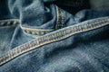 close up detail of an unbuckled leather belt on a faded pair of blue jeans Royalty Free Stock Photo