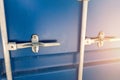 Close-up detail view of big blue metal freight cargo container door handle closed with padlock lock. Storage warehouse Royalty Free Stock Photo