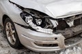 Close-up detail view of broken wrecked front car part after road collision accident due icy snowy slippery road on