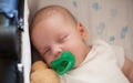 Close-up detail view of cute little peaceful baby calm sleeps soundly with pacifier in his crib Royalty Free Stock Photo