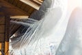 Close-up detail view of melting snow icicles on wooden alpine hut roof at windy mountain. Beatiful croocked big icicles Royalty Free Stock Photo