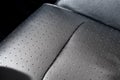 Close-up detail view of modern black perforated dotted ventilated luxury car seat. Part of dark vehicle interior. Auto Royalty Free Stock Photo