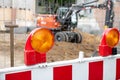 Close-up detail view orange flasher safety blinker light barrier against fence construction site work area. Security Royalty Free Stock Photo