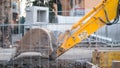 Close up detail view of the shovel bucket attachment of a yellow digging excavator tractor vehicle in motion destroying Royalty Free Stock Photo