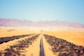 Close up detail view of train tracks leading through the desert near the city of Luderitz in Namibia, Africa. Selective focus on f Royalty Free Stock Photo