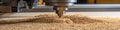 Close-up detail view of woodworking CNC router machine with sawdust covering material surface.