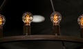 Close-up detail of vintage light bulbs in a metal hanging light fixture against a dark ceiling Royalty Free Stock Photo