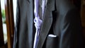 Close up detail of wedding male black suit with purple tie prepared for the groom. Action. Stylish dark men suit with a Royalty Free Stock Photo