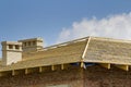 Close-up detail of wooden roof of new brick house with two white chimneys under construction. Timber frame of natural materials ag Royalty Free Stock Photo