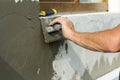 Close-up of detail of worker hand with trowel applying glue on p Royalty Free Stock Photo