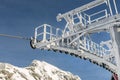 Close-up detailc of ski lift cable car gear wheels covered with icing, icicles and snow due to frost and cold weather on bright Royalty Free Stock Photo